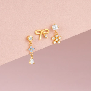 Detail of s925 silver gold stud set featuring blue zircon bow and flower charms