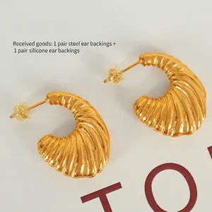 Vintage golden croissant hoop earrings with a textured ribbed design and steel backings