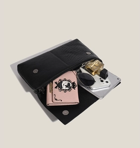 Detailed view of the black animal-textured clutch showing its interior capacity and storage