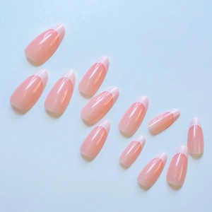 Detailed view of pink French almond press-on nails with glossy finish on a blue backdrop