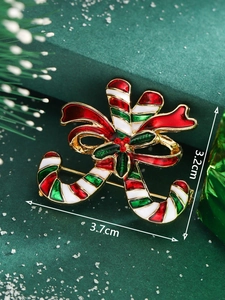 Macro view of candy cane Christmas brooch with red and green enamel and crystal accents