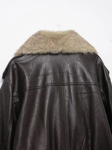 Détail d'une veste en cuir marron foncé avec col en fausse fourrure et fini texturé