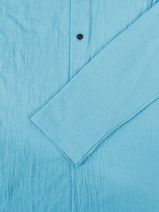 Macro shot of sky blue linen fabric texture with a black round button and stitching details