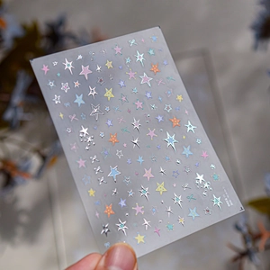 Macro shot of laser star nail stickers with silver pink and blue metallic reflective effects