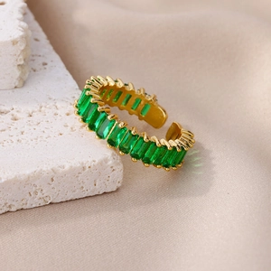 Macro view of adjustable gold ring featuring baguette-cut emerald green zircons