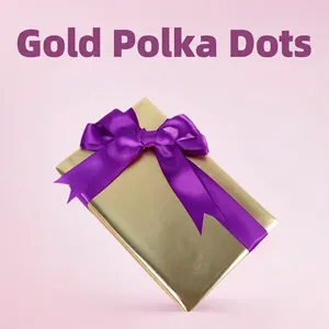 Gold metallic gift wrap paper with a large purple satin ribbon bow for birthday and holidays