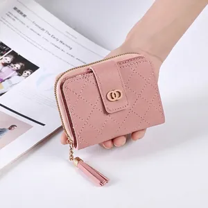 Detail der rosa gesteppten PU-Ledergeldbörse mit Goldreißverschluss und Quastenakzent