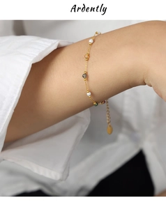 Detail of minimalist gold chain bracelet with colorful natural stone beads on a wrist