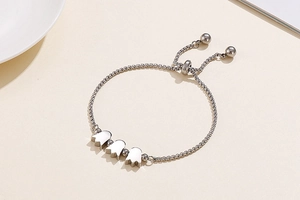 Adjustable silver tulip bracelet featuring triple charms and polished box chain detail