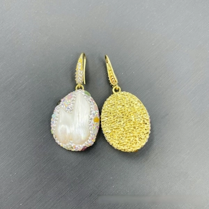 Detailed view of baroque pearl earrings with colorful crystals and golden back texture