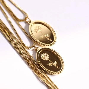 Detail view of a vintage gold double-layer necklace with oval rose embossed pendants