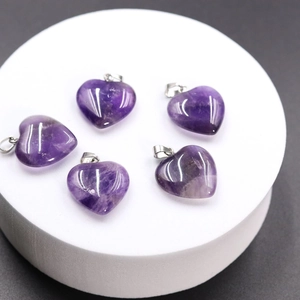 Macro view of five polished heart-shaped amethyst pendants with silver metal clasps