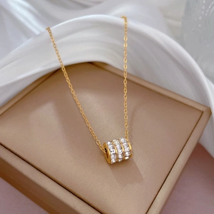 Detail of gold titanium steel cylinder pendant necklace with sparkling pavé crystals