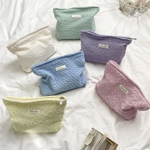 Flat lay of bubble textured makeup bags in six macaron colors with Sozakka label