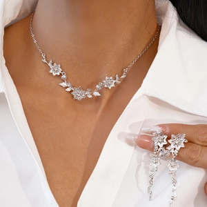 Détail du collier floral argenté et boucles d'oreilles pompons avec strass sur mannequin