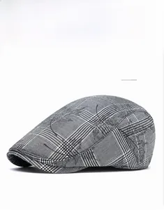 Detail of grey plaid newsboy cap featuring subtle maple leaf patterns and cotton texture