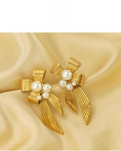 Detail of 18K gold vacuum plated bow earrings with pearls showing non-tarnish metal texture