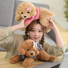 Detail of brown teddy bears in pink and denim outfits on a wooden desk setup