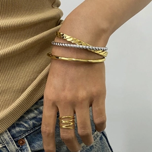 Polished 18K gold plated stainless steel bracelets and ring set worn on model wrist