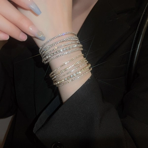 Close-up of layered diamond tennis bracelets featuring pavé cubic zirconia on wrist