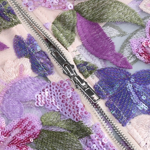 Detail of heavy embroidery and sequins on the fabric with a hidden metal zipper closure