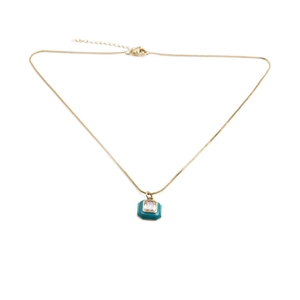 Détail du pendentif carré doré avec émail bleu sarcelle et cristal central brillant