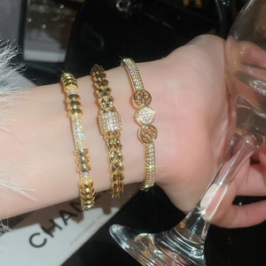 Detailed view of layered 18K gold plated zircon studded bracelets for women on a wrist