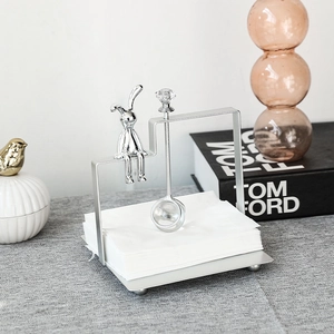 Nordic silver iron bunny napkin holder with crystal top on a gray textured surface