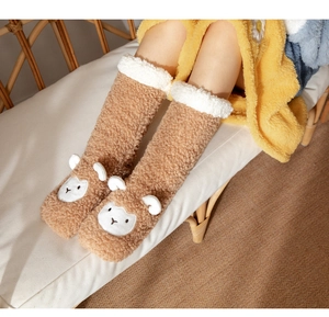 Close-up of cozy brown plush animal floor socks with white faux fur trim and soft texture