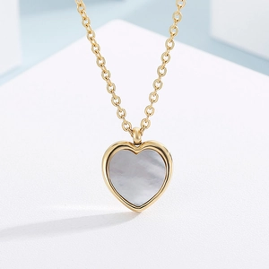Close-up of heart pendant necklace with natural white mother of pearl inlay and gold chain