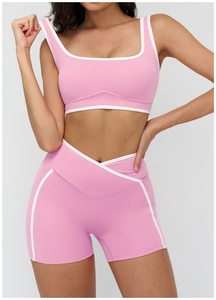Detail of pink yoga set showing the crop top's square neck and V-cross waist shorts