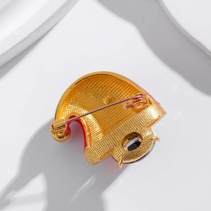Vue arrière d'une broche bonnet de Noël dorée avec finition texturée et fermoir à épingle