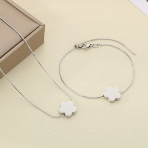 Silver snake chain jewelry set featuring minimalist six-petal flower necklace and bracelet