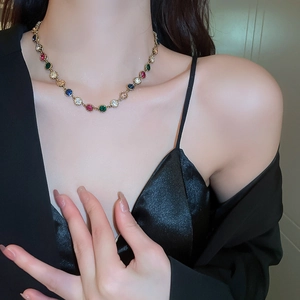 Detailed close-up of a luxury gold necklace featuring multi-colored gemstone settings