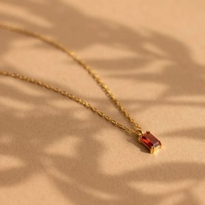 Detail of 18K gold-plated necklace with rectangular red zircon gemstone pendant