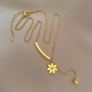 Detail showing gold steel floral necklace with curved bar pendant and STEEL engraving