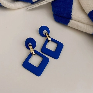 Detailed close-up of matte Klein Blue square earrings with elegant gold metal chain links