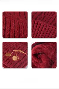 Detail view of red cable knit hat with warm fleece lining and cherry embroidery