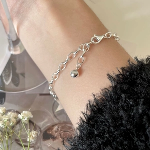 Close-up of S925 silver link bracelet with lobster clasp and round ball charm detail