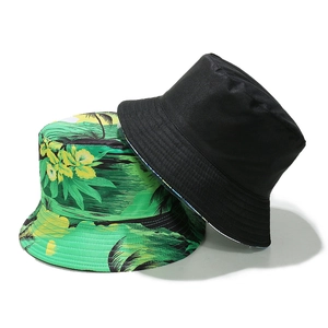 Detail of a reversible sun hat showing black fabric and green tropical palm tree prints