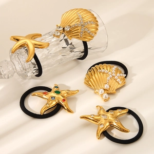 Detail of 18K gold starfish and seashell hair ties with rhinestones and pearls