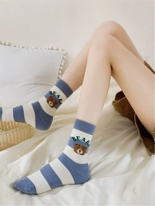 Detail of blue and white striped cotton socks with a cute brown bear embroidery