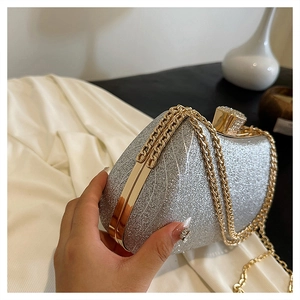 Close-up of silver sequin evening clutch with gold metal frame and chain strap