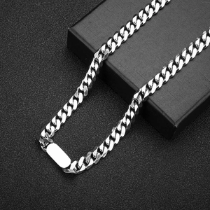 Close-up of a silver titanium steel Cuban link necklace with rectangular tag on black display