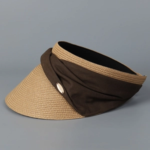 Detail of woven straw brim and brown fabric band with a gold logo on sun visor
