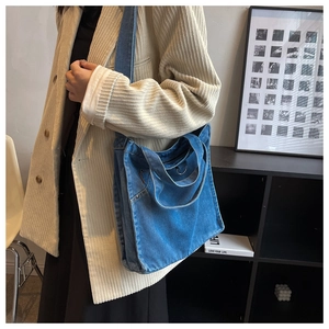 Detail of blue denim tote bag showing fabric texture and rivet pocket stitching