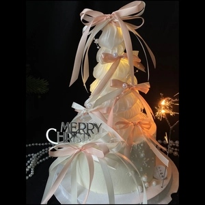 Elegant white ballet-style Christmas tree cake topper with pink bows and LED lights