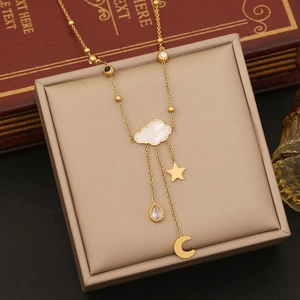 Gold stainless steel necklace with cloud, star, moon pendants on beige jewelry box