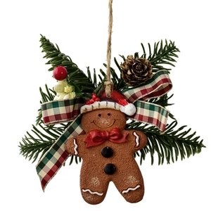 Christmas gingerbread man ornament with pine branches, pinecone and red-green plaid ribbon