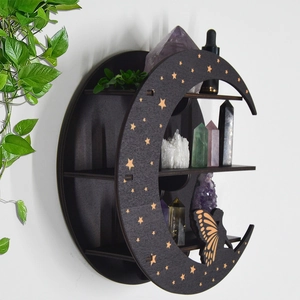 Detail of black crescent moon wooden shelf with gold stars and butterfly decorations